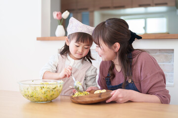 サラダを盛り付ける親子　女の子とお母さん - 781652733