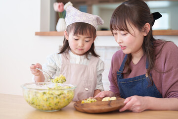 サラダを盛り付ける親子　女の子とお母さん - 781652741