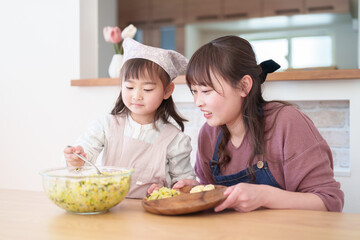 サラダを盛り付ける親子　女の子とお母さん - 781652750