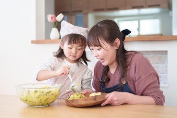 サラダを盛り付ける親子　女の子とお母さん - 781652755