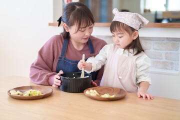 ご飯を盛り付ける親子　女の子とお母さん - 781652756