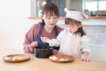 ご飯を盛り付ける親子　女の子とお母さん - 781652768