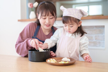 ご飯を盛り付ける親子　女の子とお母さん - 781652791