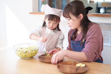サラダを盛り付ける親子　女の子とお母さん - 781652909