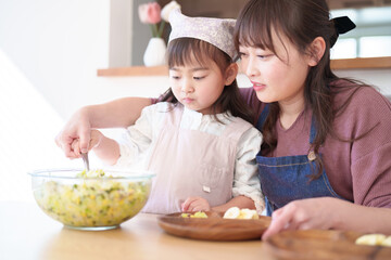 サラダを盛り付ける親子　女の子とお母さん - 781652914