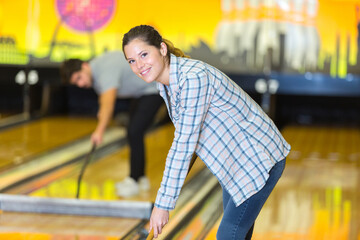 smiling young woman in a bowling alley cleaning