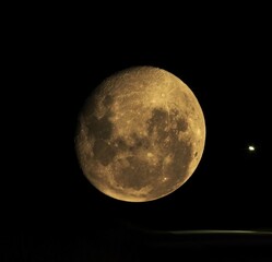 Doble exposición de la luna junto a una farola en la ruta.