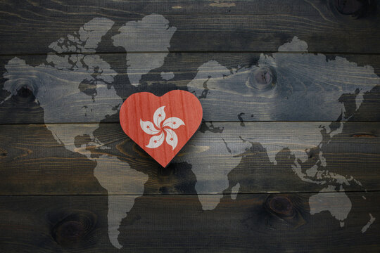 wooden heart with national flag of hong kong near world map on the wooden background.