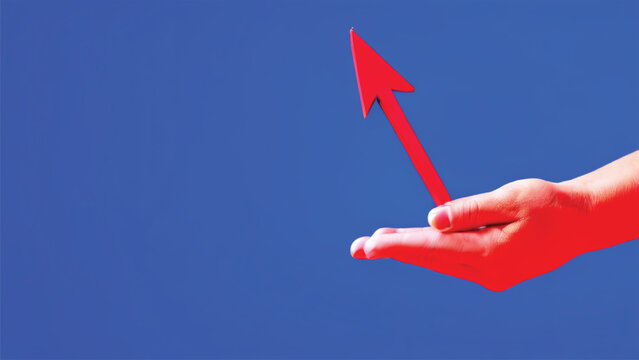 Hand holds a red arrow on blue background. Business and challenge concept.
