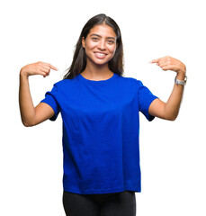 Young beautiful arab woman over isolated background looking confident with smile on face, pointing...