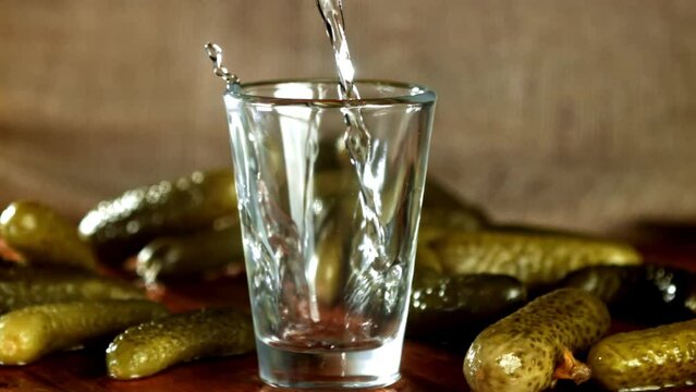 Super slow motion vodka is poured into a glass. High quality FullHD footage