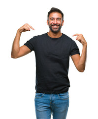 Adult hispanic man over isolated background looking confident with smile on face, pointing oneself with fingers proud and happy.