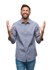 Adult hispanic man over isolated background crazy and mad shouting and yelling with aggressive expression and arms raised. Frustration concept.