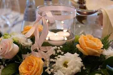centerpiece with floating candles and roses for a wedding reception