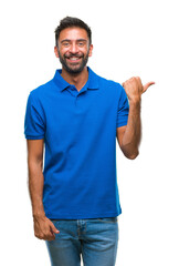 Adult hispanic man over isolated background smiling with happy face looking and pointing to the...