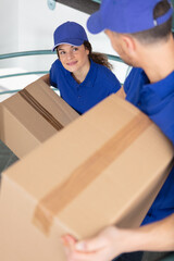 young male and female movers - obrazy, fototapety, plakaty