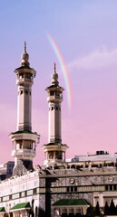 a rainbow is over a building with a rainbow in the background The minarets of the Meccan Kaaba