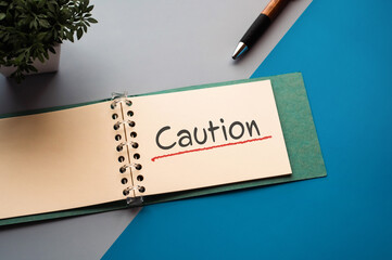 There is notebook with the word Caution. It is as an eye-catching image.