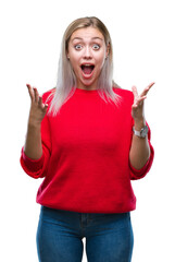 Young blonde woman wearing winter sweater over isolated background celebrating crazy and amazed for success with arms raised and open eyes screaming excited. Winner concept