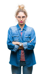 Young beautiful blonde woman wearing glasses over isolated background skeptic and nervous,...