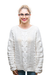 Young beautiful blonde woman wearing glasses over isolated background with a happy and cool smile...