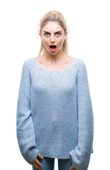 Young beautiful blonde and blue eyes woman wearing winter sweater over isolated background afraid...