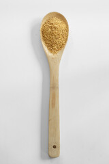 Golden roasted flax and wooden spoon on white