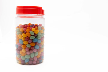 Colorful jelly beans in a clear jar with red lid