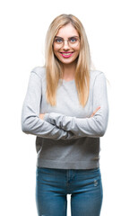 Obraz premium Young beautiful blonde woman wearing glasses over isolated background happy face smiling with crossed arms looking at the camera. Positive person.