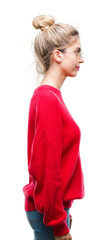 Young beautiful blonde woman wearing red sweater and glasses over isolated background looking to side, relax profile pose with natural face with confident smile.