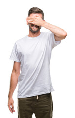 Fototapeta premium Young handsome man over isolated background smiling and laughing with hand on face covering eyes for surprise. Blind concept.