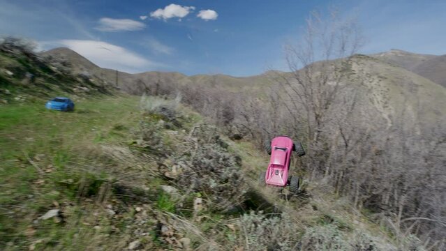 Pink RC car tumbling off ledge of canyon road