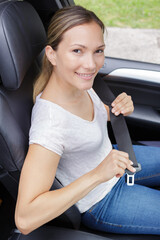close up of woman hands fastening seat belt in car - 781665551