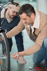 Obraz premium father and son repairing a bicycle in a garage