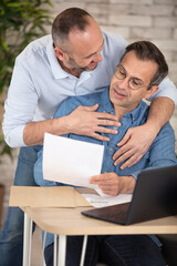 happy gay couple working together in office - obrazy, fototapety, plakaty