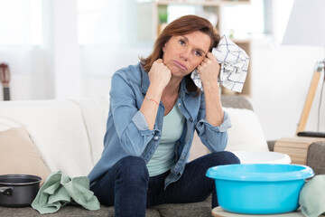 frustrated woman cleaning house sitting on the sofa - obrazy, fototapety, plakaty