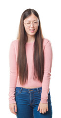 Fototapeta premium Young Chinese woman over isolated background wearing glasses winking looking at the camera with sexy expression, cheerful and happy face.