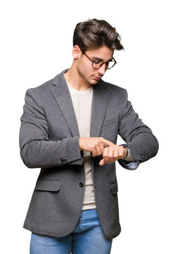 Young business man wearing glasses over isolated background Checking the time on wrist watch, relaxed and confident