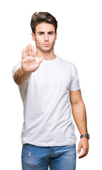 Young handsome man wearing white t-shirt over isolated background doing stop sing with palm of the...