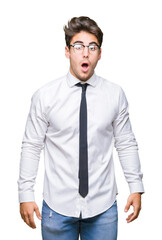 Young business man wearing glasses over isolated background In shock face, looking skeptical and sarcastic, surprised with open mouth