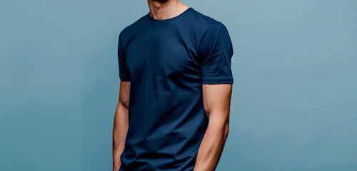 A man's relaxed stance is perfectly complemented by his choice of attire--a navy blue half-sleeve t-shirt--captured against a smooth light blue background in stunning HD clarity