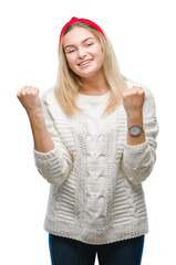 Obraz na płótnie Canvas Young caucasian woman wearing winter sweater over isolated background very happy and excited doing winner gesture with arms raised, smiling and screaming for success. Celebration concept.