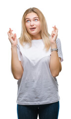 Fototapeta premium Young caucasian woman over isolated background smiling crossing fingers with hope and eyes closed. Luck and superstitious concept.