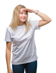 Fototapeta premium Young caucasian woman over isolated background very happy and smiling looking far away with hand over head. Searching concept.