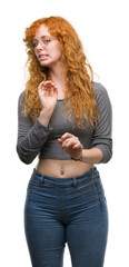 Young redhead woman disgusted expression, displeased and fearful doing disgust face because aversion reaction. With hands raised. Annoying concept.