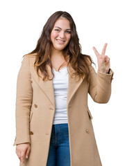 Beautiful plus size young woman wearing winter coat over isolated background smiling with happy face winking at the camera doing victory sign. Number two.