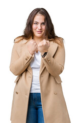 Beautiful plus size young woman wearing winter coat over isolated background Ready to fight with...