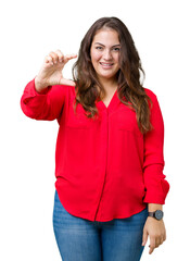 Obraz na płótnie Canvas Beautiful plus size young business woman over isolated background smiling and confident gesturing with hand doing size sign with fingers while looking and the camera. Measure concept.