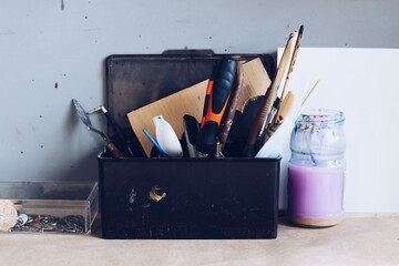 pencils and tools in an organizer, brushes and a container of water