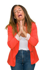 Beautiful middle age business adult woman over isolated background begging and praying with hands...